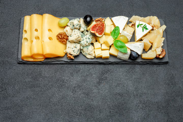 various types of cheese on stone board
