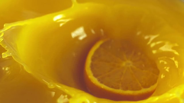 Orange slice falls in fresh juice