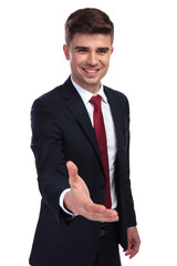 happy young businessman making a welcoming gesture