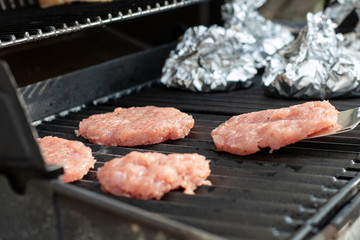Raw burgerpatties are grilled