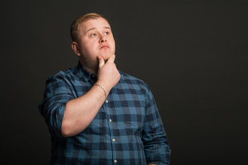 Portrait of Fat caucasian man thinking and looking up to copyspace