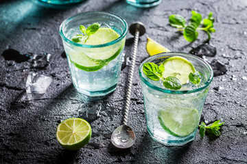 Cold Mojito with ice and alcohol on black rock
