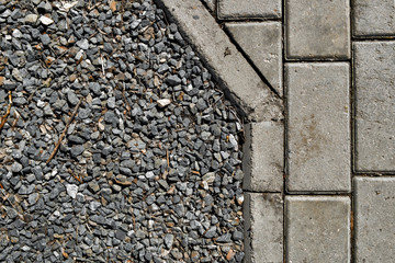 Crushed stone and pavement tiles. Urban background. Combined