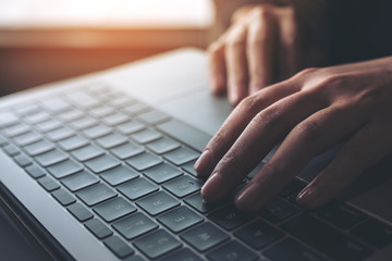 Closeup image of business woman working and typing on laptop keyboard