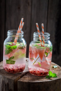 Closeup of water in jar with pomegranate and watermelon