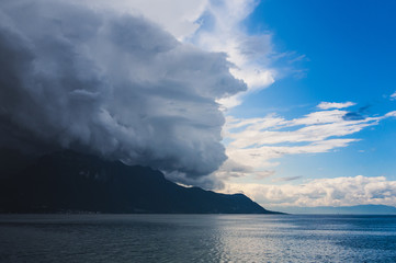 The storm is coming to the lake from the mountains. Big clouds, rain. Dark storm clouds.