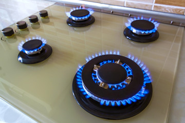 Closeup shot of blue fire from domestic kitchen stove. Gas cooker with burning flames propane gas.