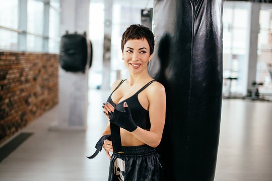cheerful good-looking woman wrapping hahds with boxing wraps. martial art. being fond of boxing. every day workout