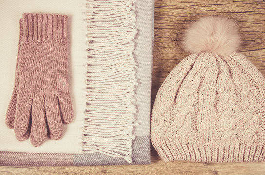 Warm winter knitted clothes on a wooden background.
