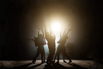 young people standing around with raised hands. praying together to the sun.influence of sect. worship light. worship the Sun. Sun cult. dancing movies - obrazy, fototapety, plakaty