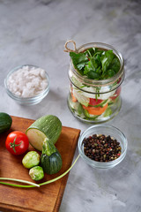 Fresh vegetable salad and ripe veggies on cutting board over white background, close up, selective focus