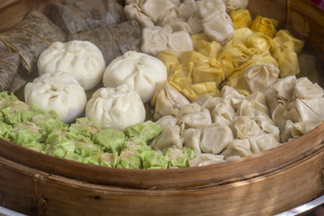 Fresh dim sum in bamboo steamer, chinese cuisine for sale at a local market in Bali, Indonesia. Close up