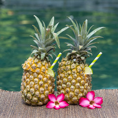 Pina colada cocktail in fresh two pineapples near swimming pool. Island Bali, Indonesia