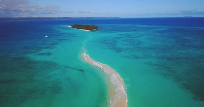 Aerial view of a desert island with a clear and transparent sea and a pristine beach. Concept of: holidays, maldives, dream landscapes.