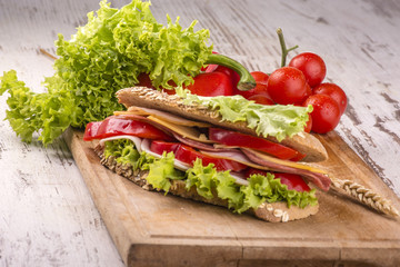 Sandwich with ham, cheese, green salad and radish