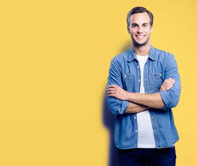 Portrait of young man standing in crossed arms pose