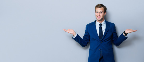 Smiling businessman showing something or copyspace