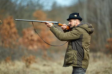 Hunter with gun in the forest
