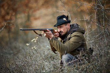 Fototapeta premium Hunter with gun in the forest