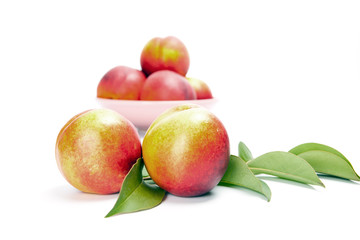 Fototapeta na wymiar fresh peach fruits with green leaves isolated on white background