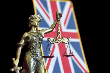 Statue of Lady Justice with United Kingdom flag
