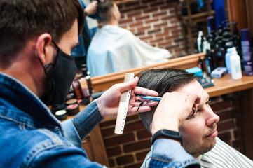 master hairdresser cuts a man in the salon