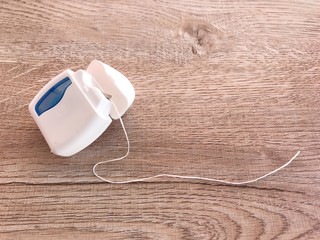 Dental floss On a wooden board And space for text or symbols. In the concept of good dental health.