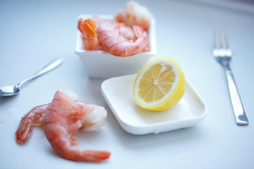 row tiger shrimp with lemon on white