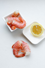 row tiger shrimp with lemon on white
