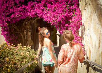 two blond friends going downstairs through the flowers