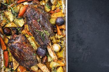 Venison knuckle with fried potatoes and vegetable as top view in a casserole with copy space right