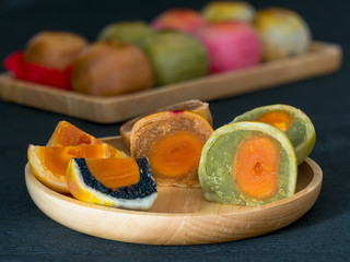 Closeup chinese cake in wooden plate on dark background