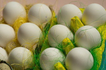 Chicken eggs in colored paper eco-friendly packaging with decorative sisal. Close-up photo, macro. Easter background Food concept 