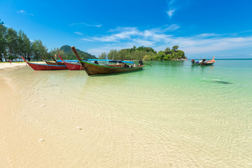 Fototapeta na wymiar White sand beach and Long-tail boat at Kham-Tok Island (koh-kam-tok), The beautiful sea Ranong Province, Thailand.