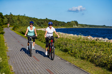 Women riding bicycles at seaside