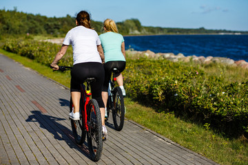 Women riding bicycles at seaside