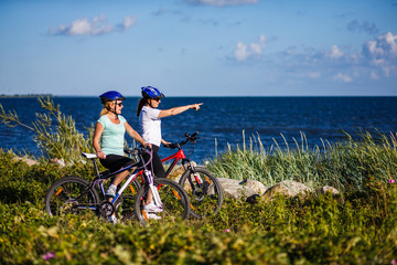 Obraz premium Women riding bicycles at seaside