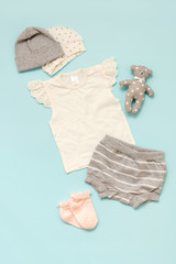 set of children's clothes on a blue background for the girl: a T-shirt, shorts, a selection of caps and socks. Collection spring-summer