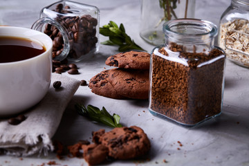 Morning coffee in white cup, chocolate chips cookies on homespun napkin, close-up, selective focus