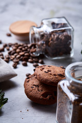 Roasted coffee beans get out of overturned glass jar on homespun tablecloth, selective focus, side view