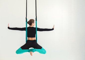 Woman practicing fly yoga over white background