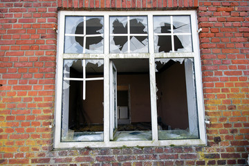 Window in abandoned building exposed to vandalism