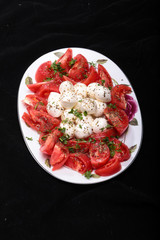 Caprese salad with tomatoes,  mozzarella and herbs