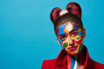 Pop art portrait of model wearing red jacket. Girl has saturated make up with bright geometrical...