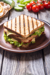 Club sandwich with tomatoes , cucumber , ham and cheese
