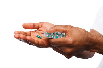 Hand holding a pill isolated on white background