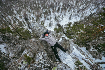 Man hiker have rest at mountain top, relax lying on rock.