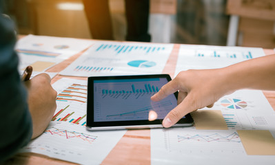 Business people pointing chart on digital tablet screen.