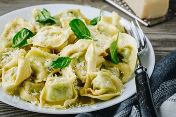 Italian ravioli pasta with spinach and ricotta on wooden background