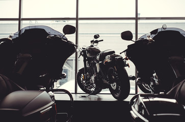image of a new motorcycle in the store. Motorcycles and accessories in a modern motorcycle store. cool motorcycle in the motor cabin silhouette. The concept of motorcycles